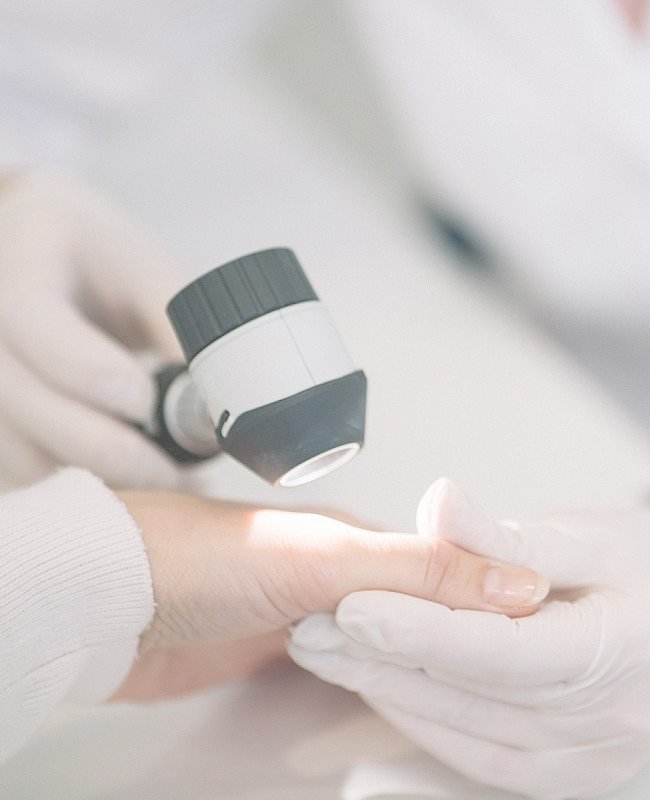 Dermatologist using advanced skin care tool to examine issues on patient's hand